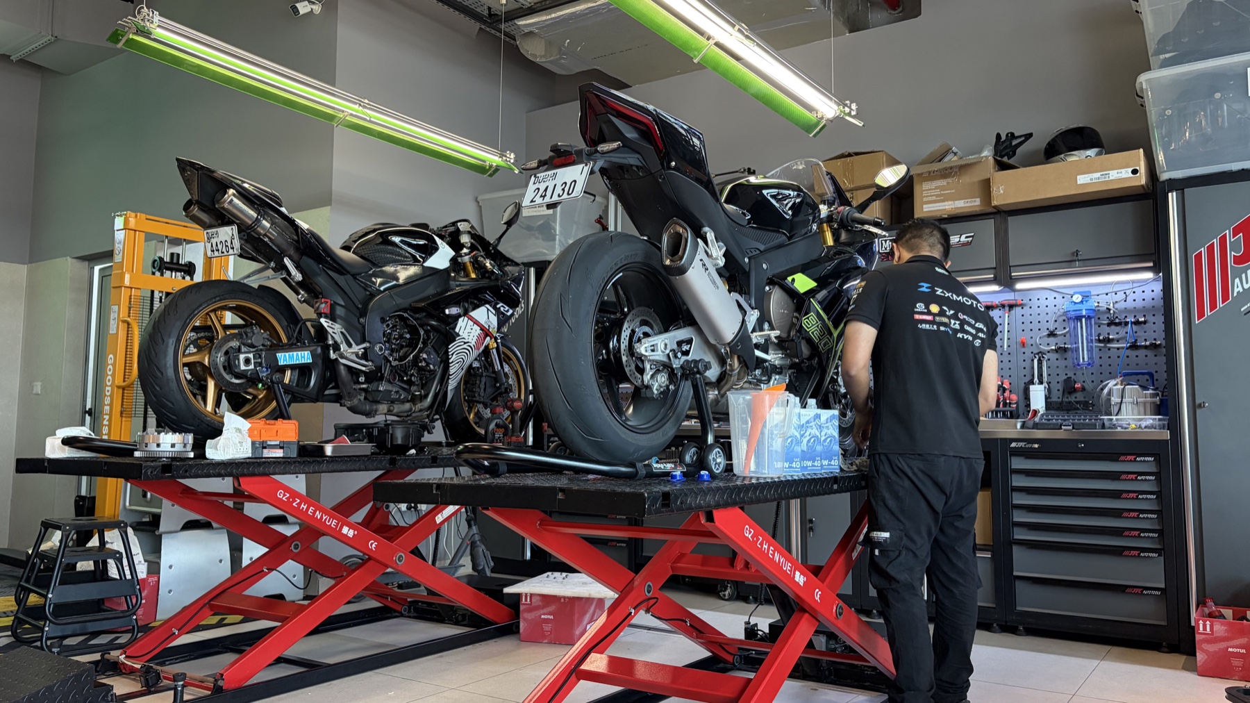 Motorcycles being serviced on workshop lifts